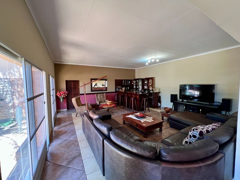 Spacious living area featuring tiled flooring, large sliding glass doors for natural light, and a built-in bar area.