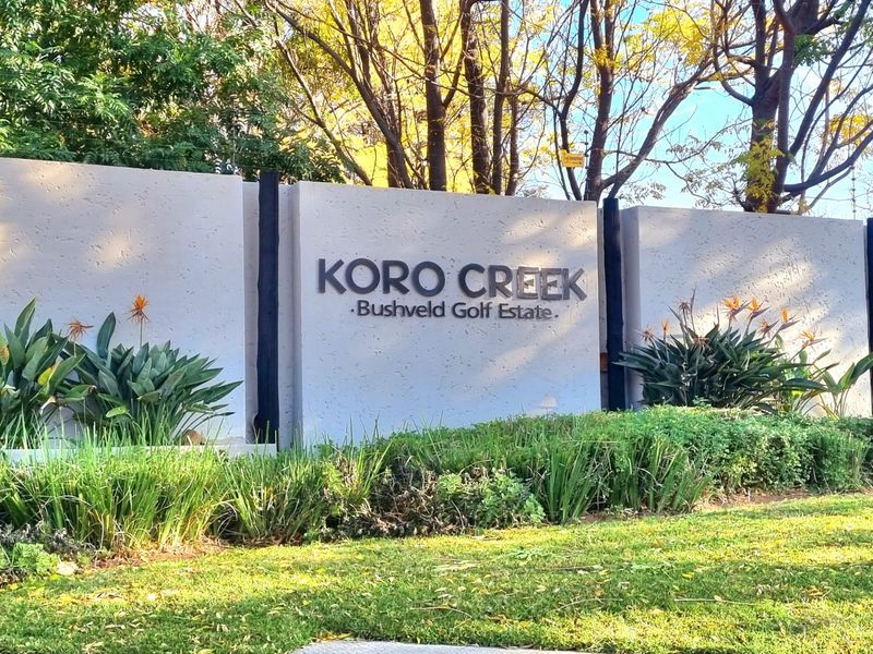 Entrance signage for Koro Creek Bushveld Golf Estate, featuring a well-maintained boundary wall and landscaped garden area.