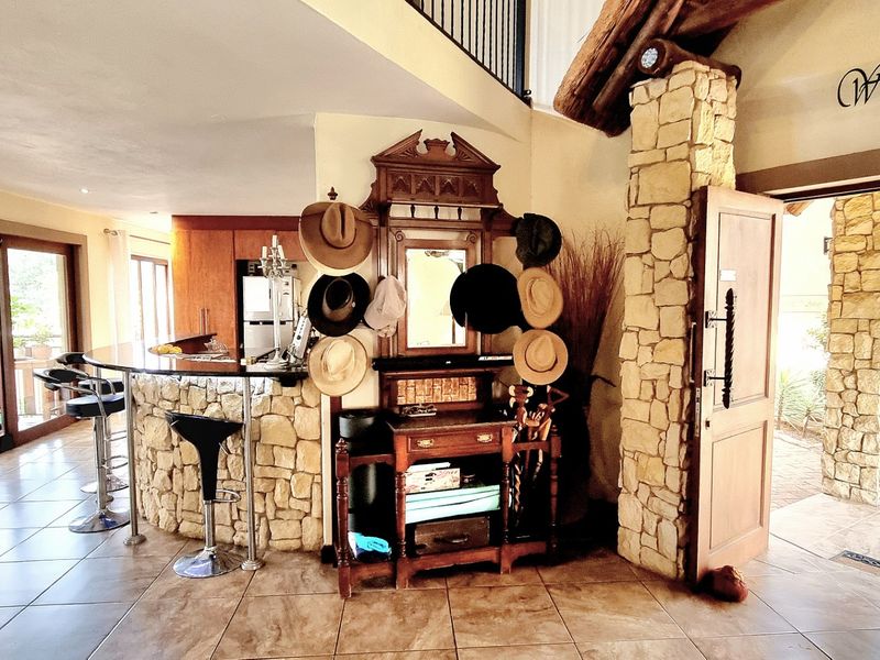 Welcoming entrance area featuring rustic stone cladding, tiled flooring, and a built-in bar counter, leading into the main living space.
