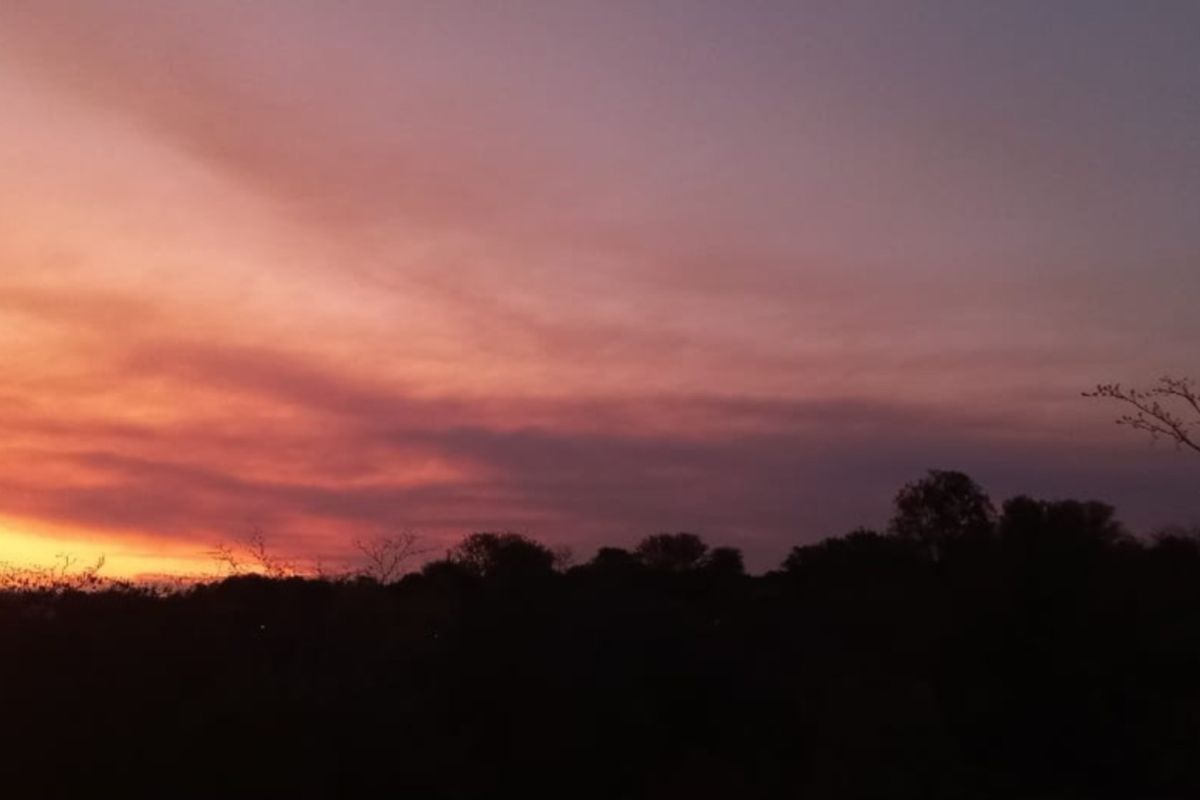 A scenic view of the horizon at sunset, showcasing the natural landscape and sky over the vacant residential land.