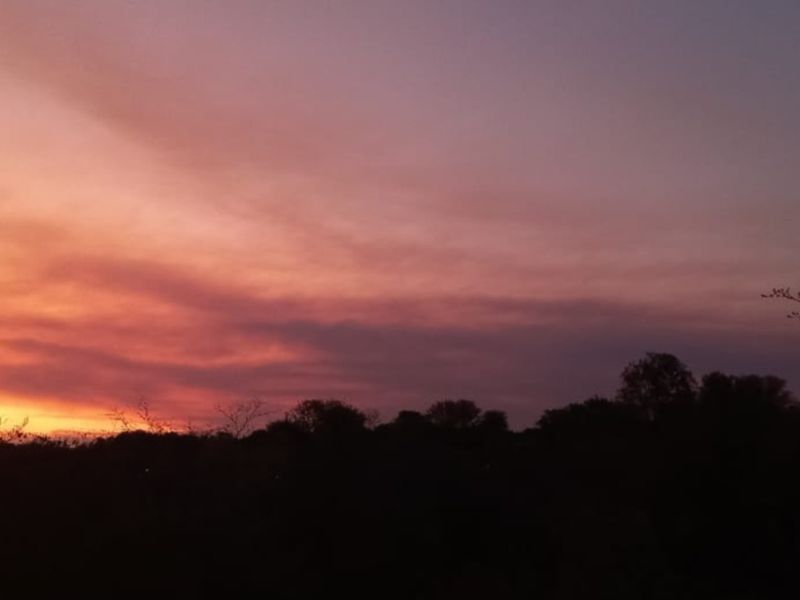A scenic view of the horizon at sunset, showcasing the natural landscape and sky over the vacant residential land.
