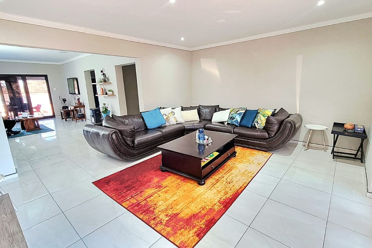 Spacious living area featuring neutral walls, modern tiled flooring, and recessed downlighting, offering a bright and open layout.