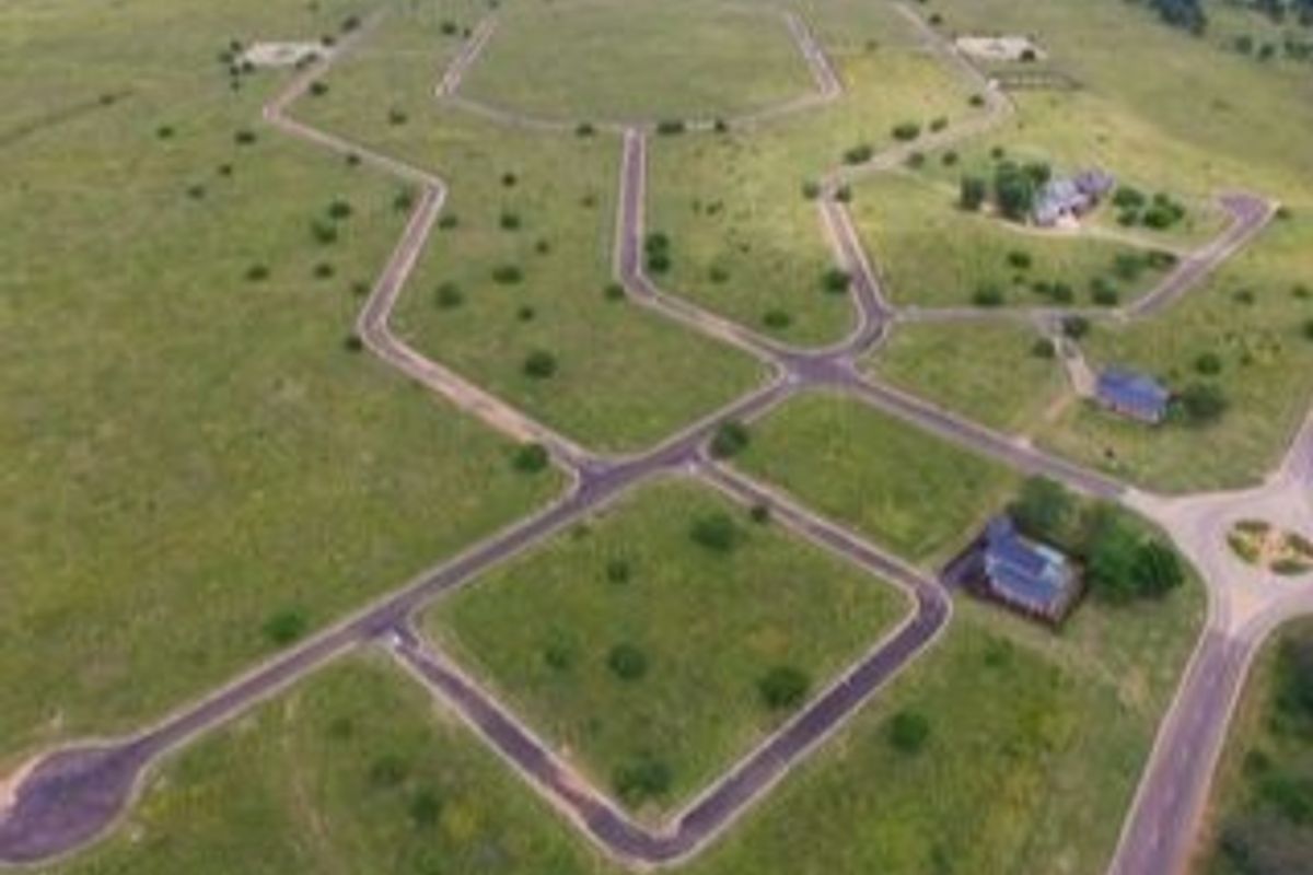 An aerial view of a residential estate development showing paved road infrastructure and multiple vacant plots.