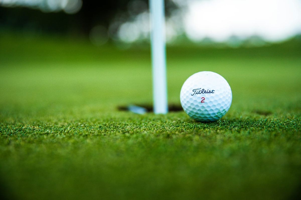 A close-up view of a golf ball on a putting green, highlighting the manicured landscape of the golf course.