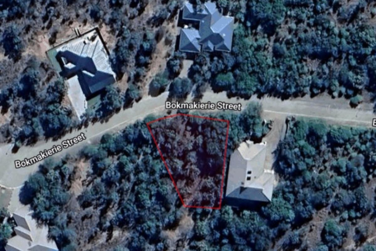 An aerial view of a vacant residential plot located on Bokmakierie Street, surrounded by established trees and neighboring properties.