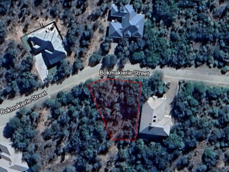 An aerial view of a vacant residential plot located on Bokmakierie Street, surrounded by established trees and neighboring properties.