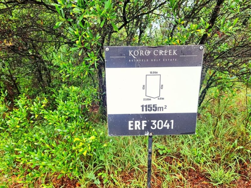 A sign displaying the erf number and dimensions for a 1155 square meter vacant residential plot located in Koro Creek Bushveld Golf Estate.