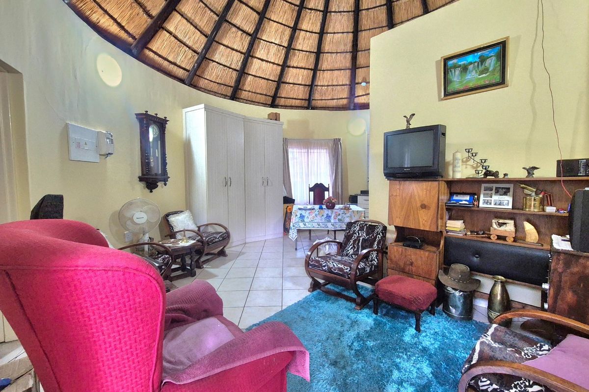A living area featuring a distinctive high thatched ceiling and tiled flooring, offering a unique architectural character.