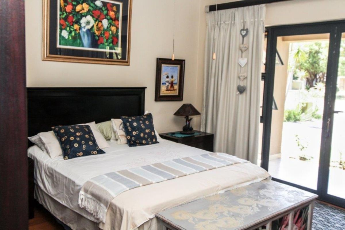 A well-maintained bedroom featuring hardwood flooring and a sliding glass door providing direct access to the outdoor area.