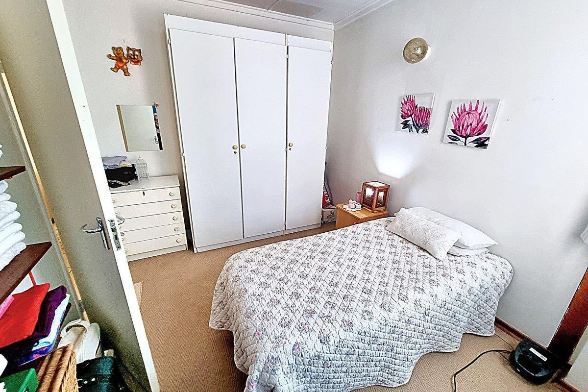 A functional bedroom featuring a built-in wardrobe, carpeted flooring, and coved ceiling details.