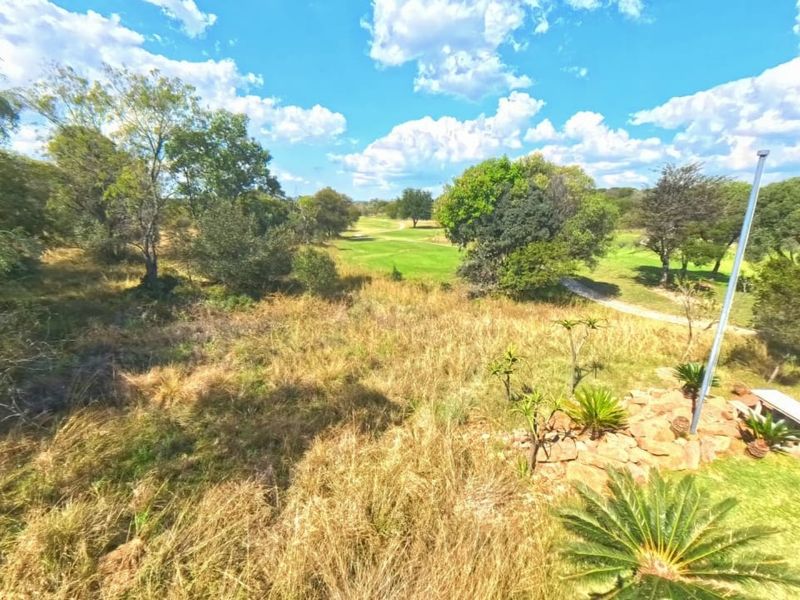 A scenic view overlooking a golf course with established trees and a landscaped garden area.
