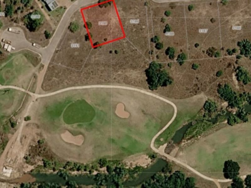 Aerial view of a vacant residential land plot situated in a golf estate, highlighting the property boundaries and surrounding landscape.