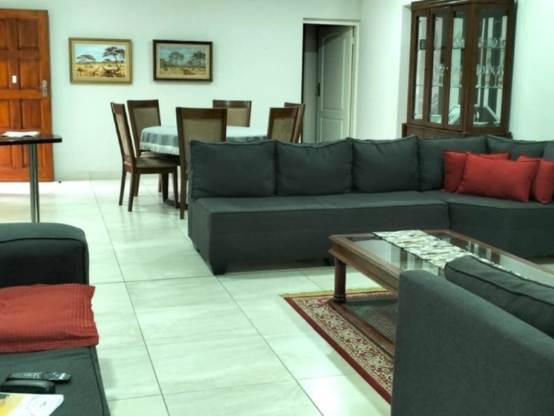 Spacious open-plan living and dining area featuring neutral tiled flooring and direct access to an outdoor patio through sliding glass doors.