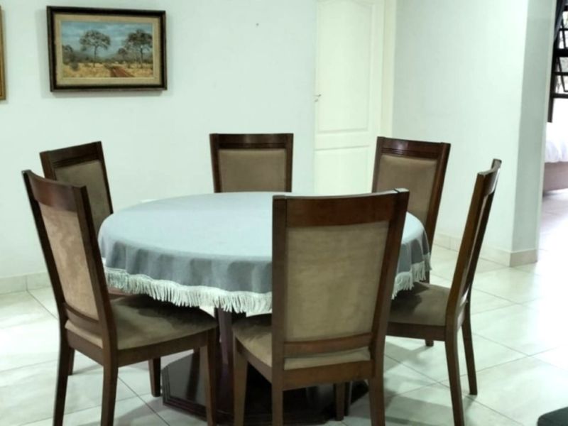 A dining room featuring tiled flooring and neutral walls, providing a functional space for family meals.