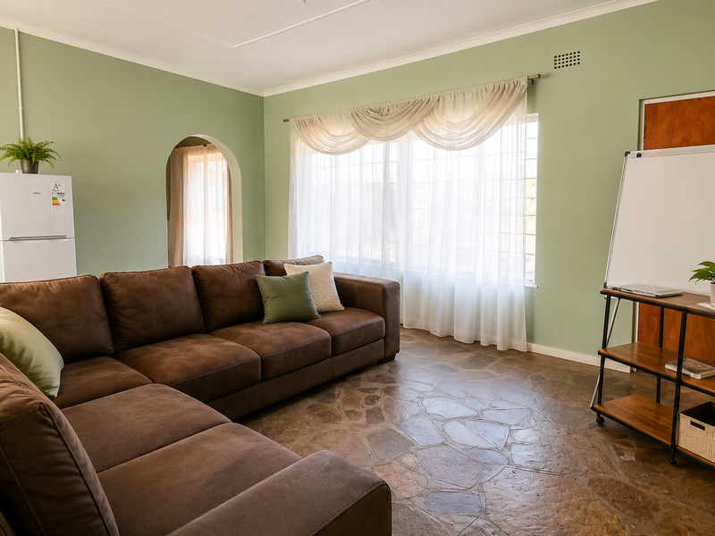 A living room featuring distinctive stone flooring, an arched doorway, and soft green walls, providing a comfortable and characterful living space.