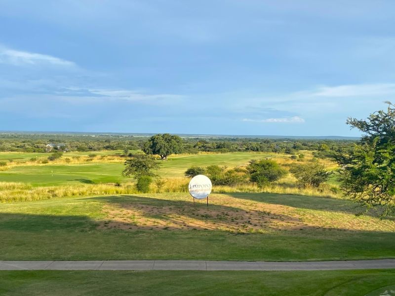 A scenic elevated view overlooking a sprawling golf course and natural landscape, showcasing the expansive outdoor environment of the property.