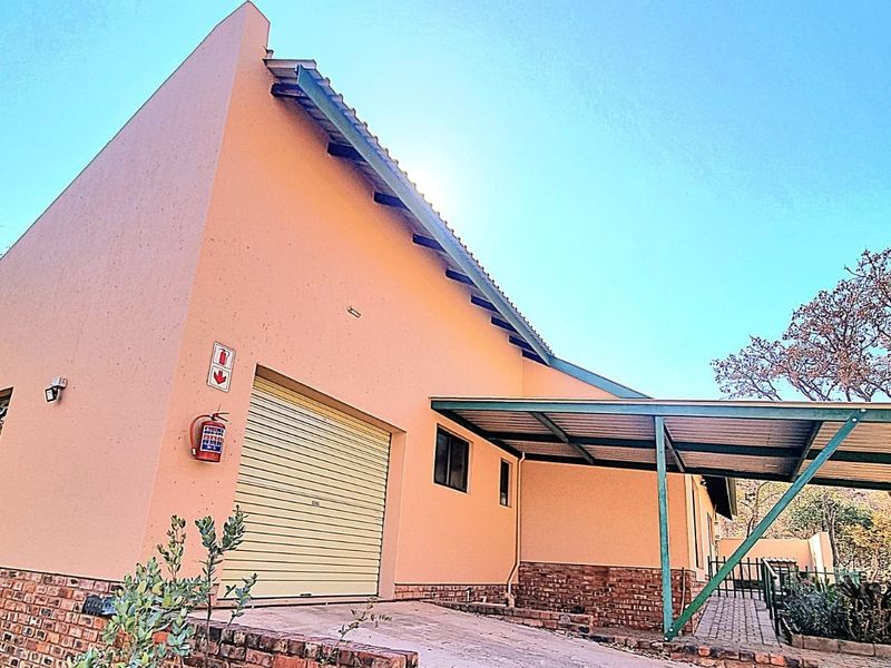 Exterior view of the property featuring a roller garage door, attached carport, and brick base detailing.