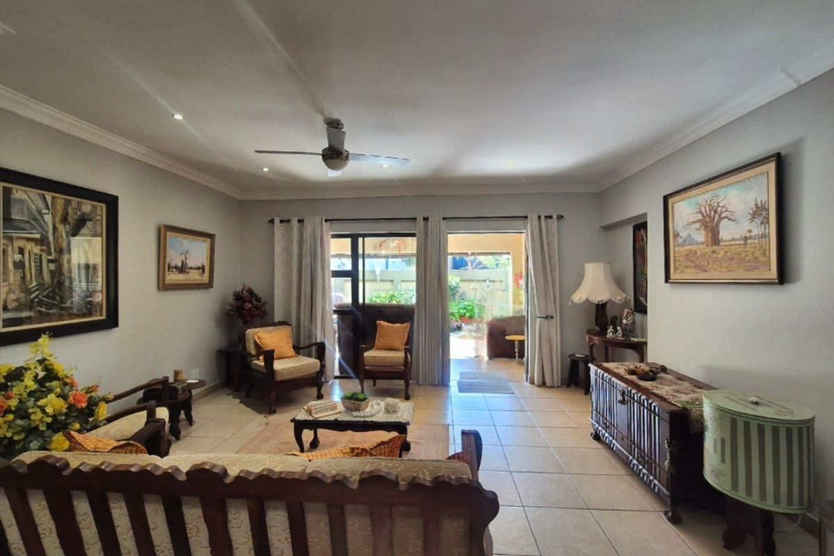 Spacious living room featuring tiled flooring, recessed lighting, a ceiling fan, and sliding glass doors providing access to the outdoor patio area.