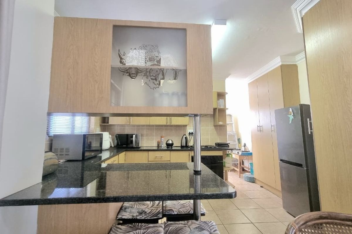 Functional kitchen featuring granite countertops, light wood-finish cabinetry, built-in cooking appliances, and a convenient breakfast nook area.