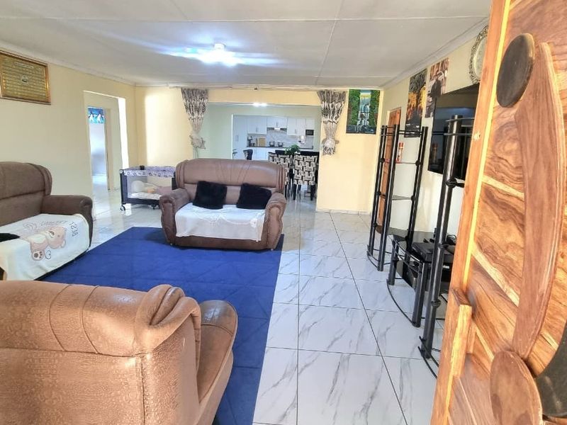Open plan living area featuring tiled flooring and a direct view into the kitchen space.
