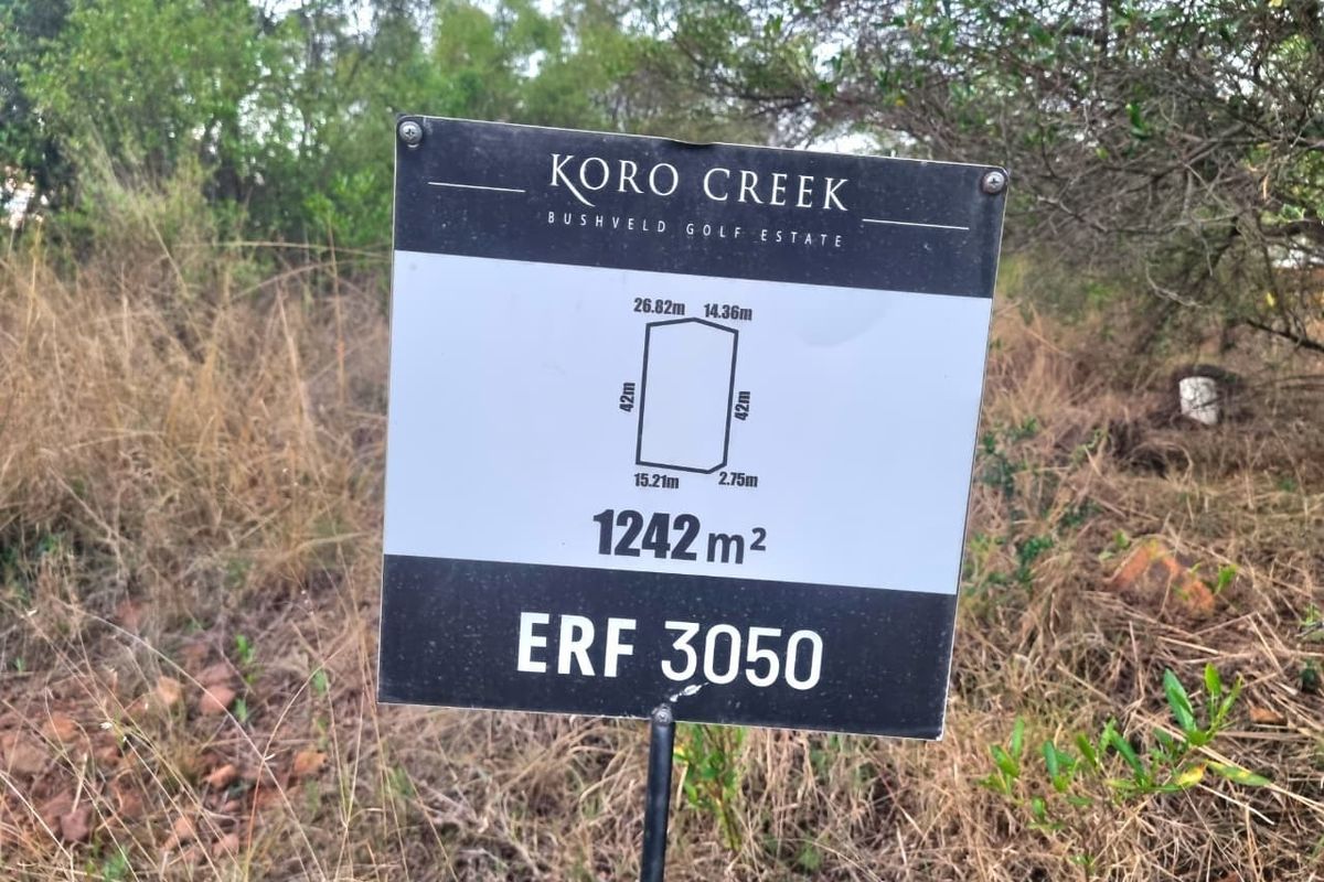A property signage board displaying the erf number and dimensions for a 1242 square meter residential plot in Koro Creek Bushveld Golf Estate.