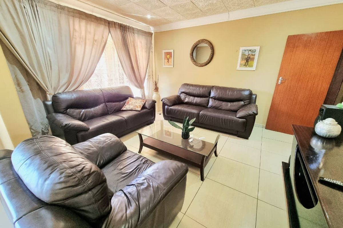 A comfortable living room featuring tiled flooring and a textured ceiling, providing a functional and inviting space for relaxation.