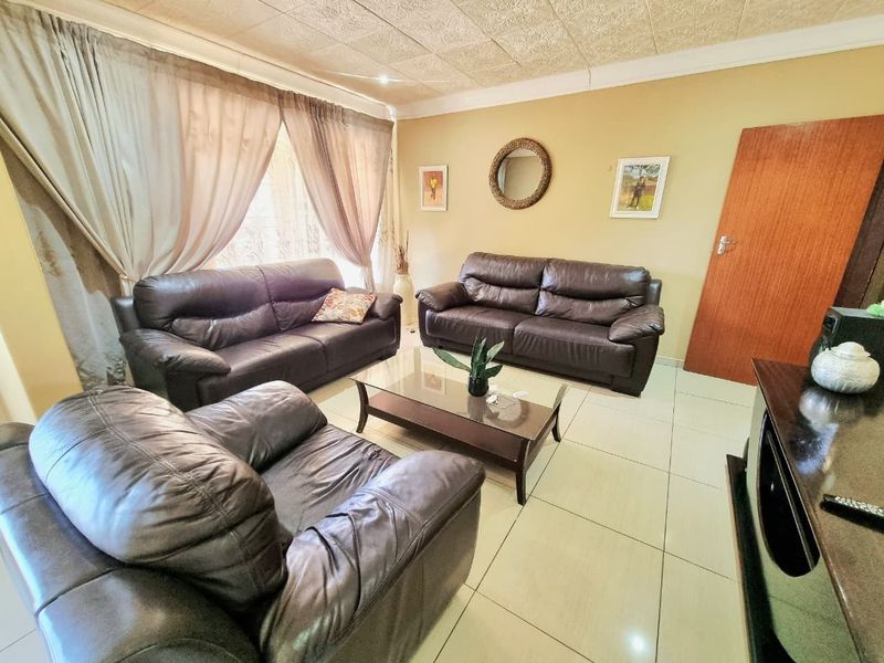 A comfortable living room featuring tiled flooring and a textured ceiling, providing a functional and inviting space for relaxation.