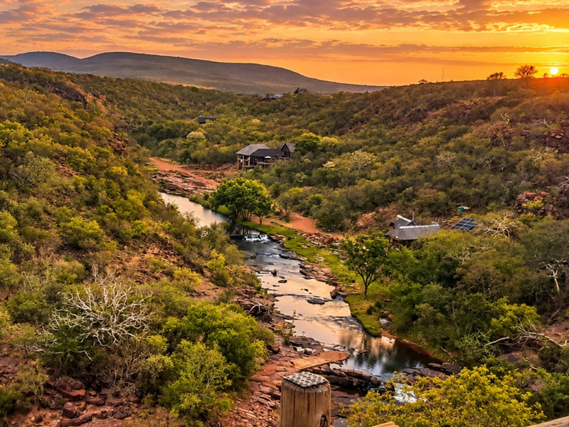 A stunning sunset view overlooking a natural river valley and surrounding bushveld landscape on the farm property.