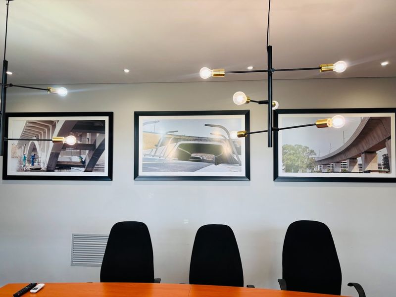 A professional office space featuring modern pendant lighting, recessed ceiling lights, and integrated HVAC ventilation, creating a clean and functional work environment.