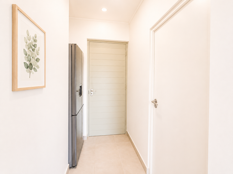 A clean, well-maintained hallway featuring neutral tiled flooring, recessed lighting, and modern internal doors, providing a bright and welcoming transition space.