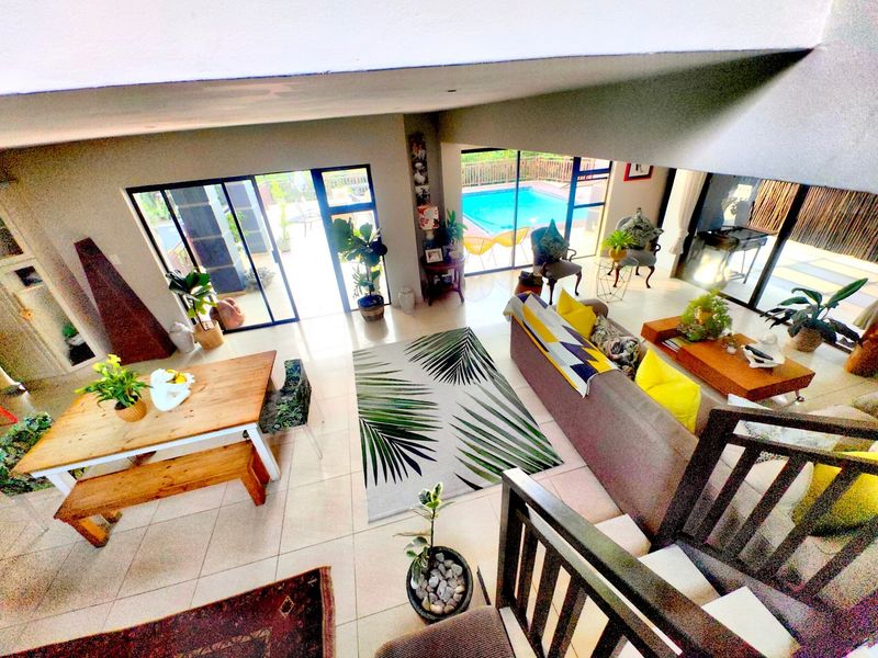 Spacious open-plan living and dining area featuring large sliding glass doors that provide seamless access to the outdoor pool area.
