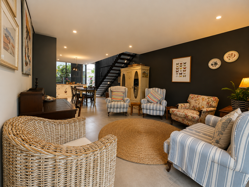 Spacious open-plan living and dining area featuring modern tiled flooring, recessed lighting, and a striking staircase with a contemporary metal balustrade.