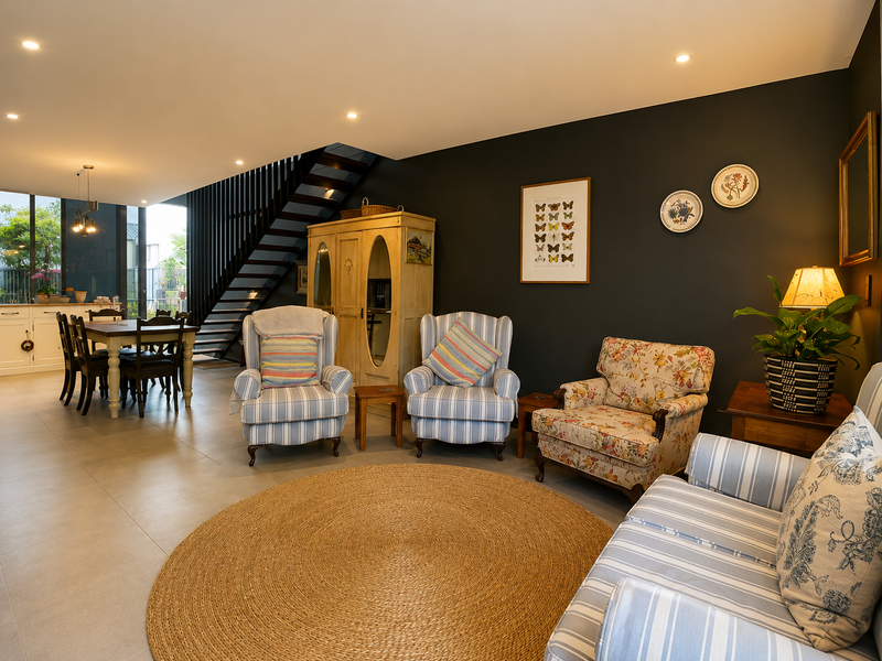 Spacious open-plan living and dining area featuring modern tiled floors, recessed lighting, and a striking staircase, with seamless access to the outdoor patio.