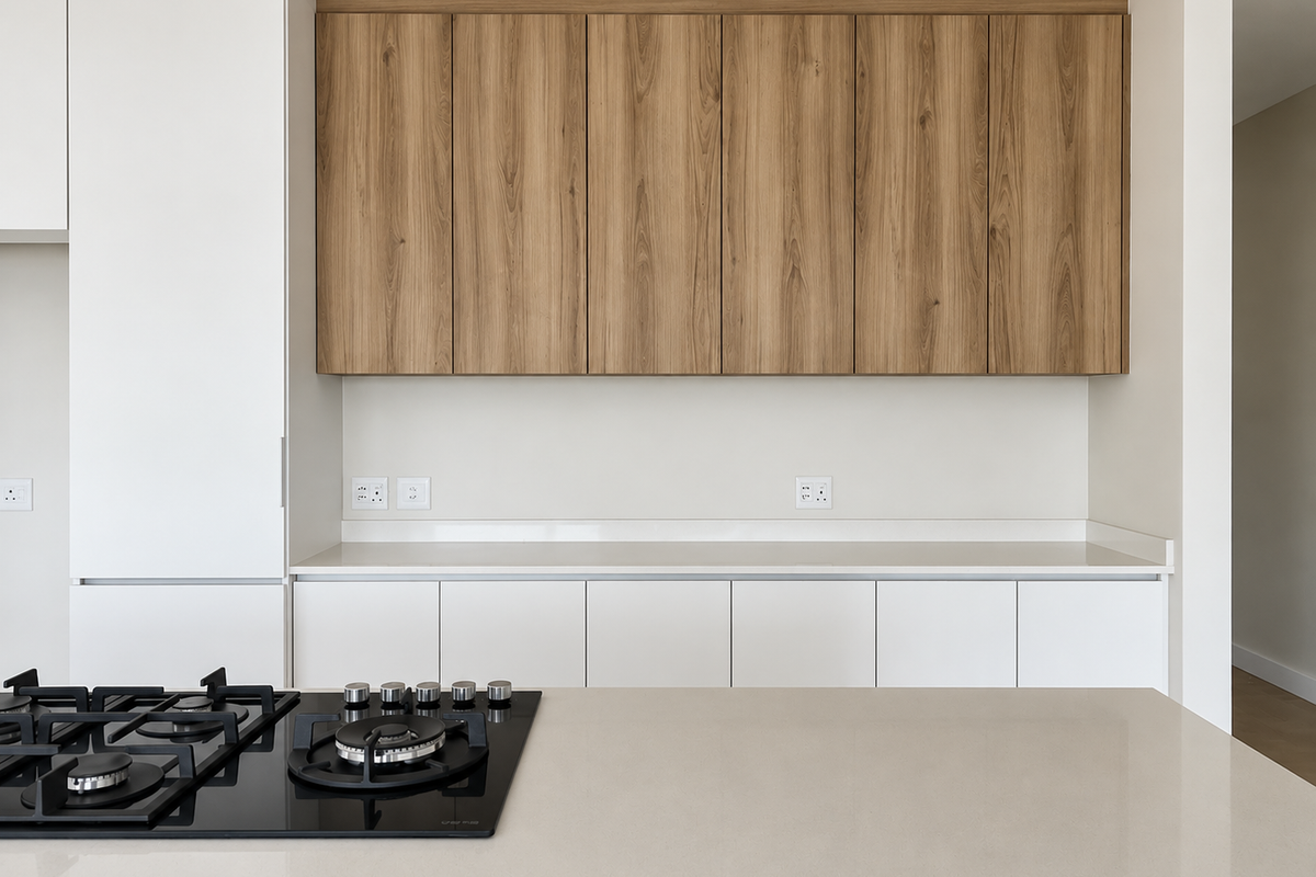 Modern kitchen featuring sleek white lower cabinetry, wood-grain upper cabinets, stone countertops, and a built-in gas hob.