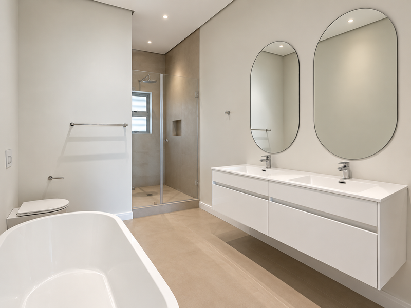 Modern, high-end bathroom featuring a double vanity, freestanding bathtub, and a spacious walk-in shower with a recessed niche and glass enclosure.