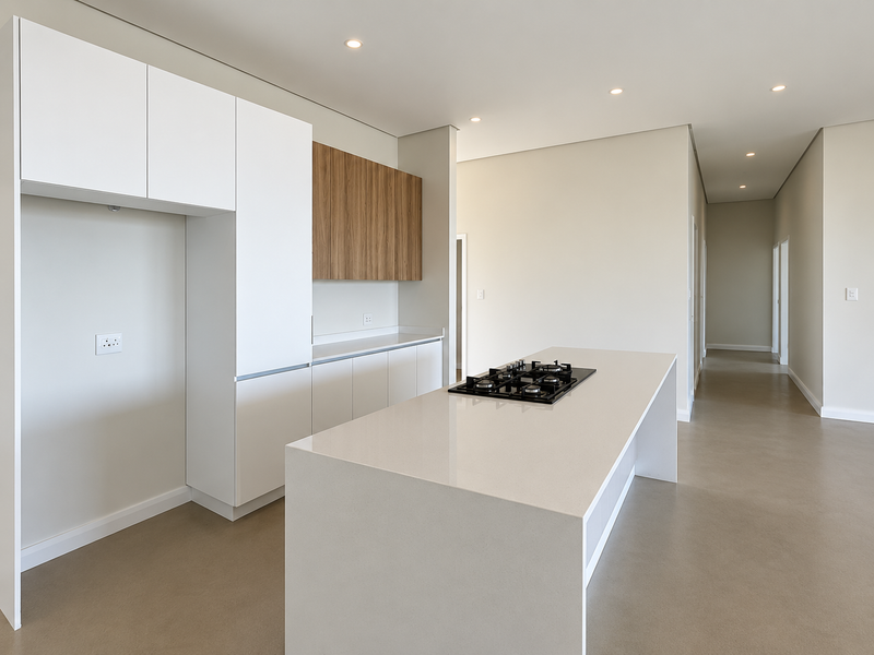 Modern, minimalist kitchen featuring a central island with a built-in gas cooktop, sleek white cabinetry, and stone countertops in an open-plan layout.