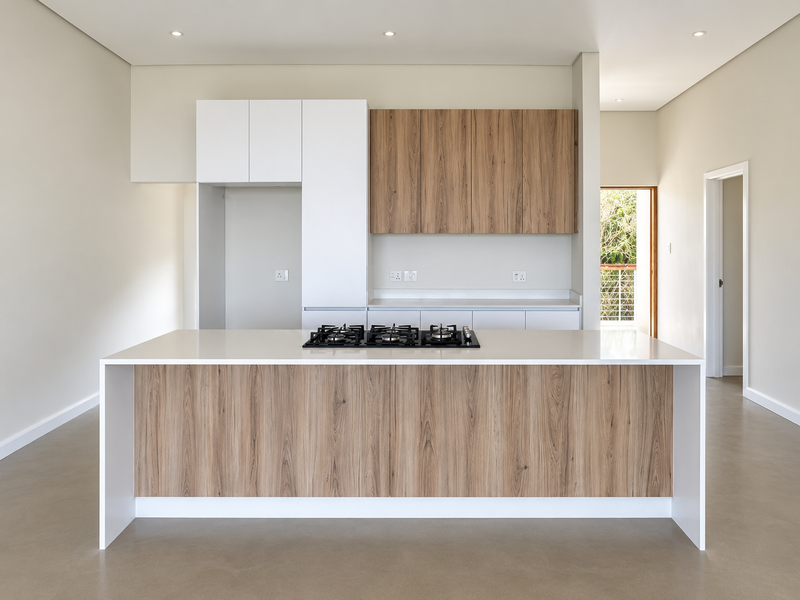 Modern kitchen featuring a central island with a built-in gas hob, sleek wood-grain and white cabinetry, and high-quality quartz countertops in an open-plan layout.