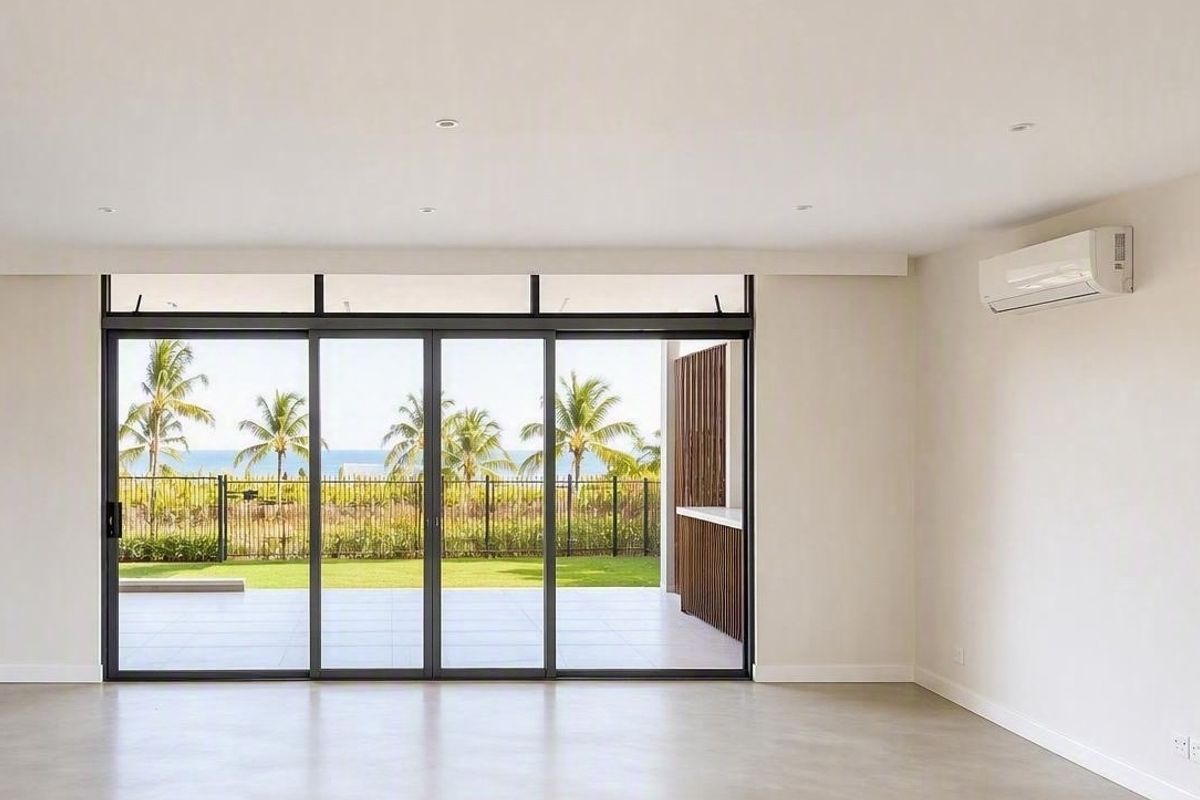 Bright and spacious living area featuring large sliding glass doors that open to a patio with scenic views, complemented by modern air conditioning.