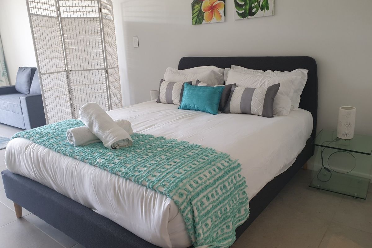 A well-maintained bedroom featuring neutral tiled flooring and a clean, modern aesthetic.