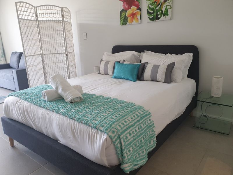 A well-maintained bedroom featuring neutral tiled flooring and a clean, modern aesthetic.