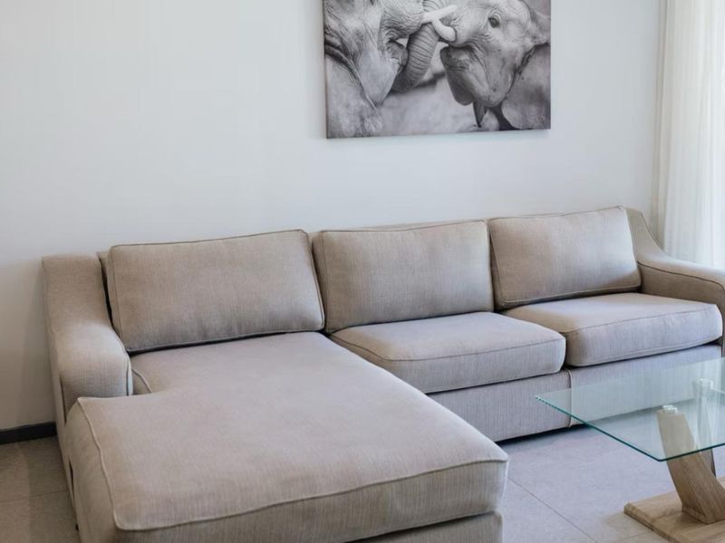 A bright and modern living room area featuring neutral tiled flooring and a clean, minimalist aesthetic.