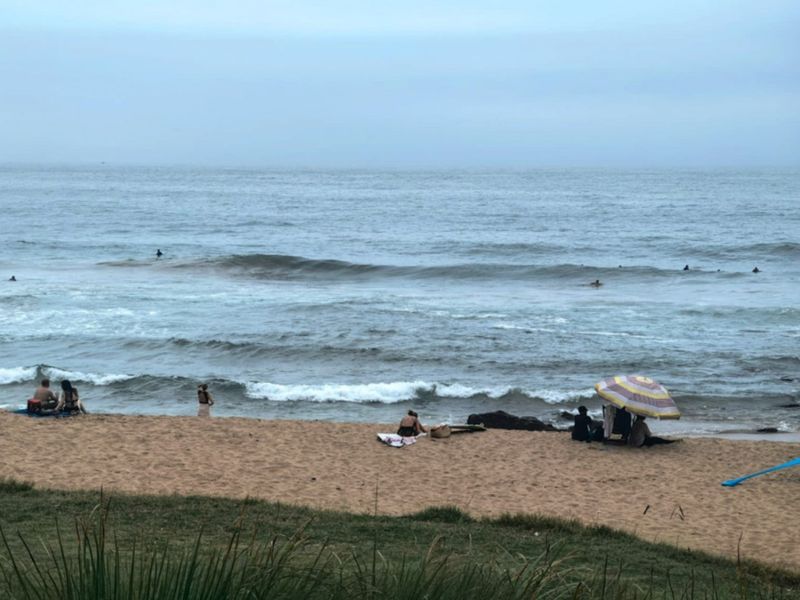 A scenic view of the ocean and sandy beach, highlighting the property's proximity to the coastline.