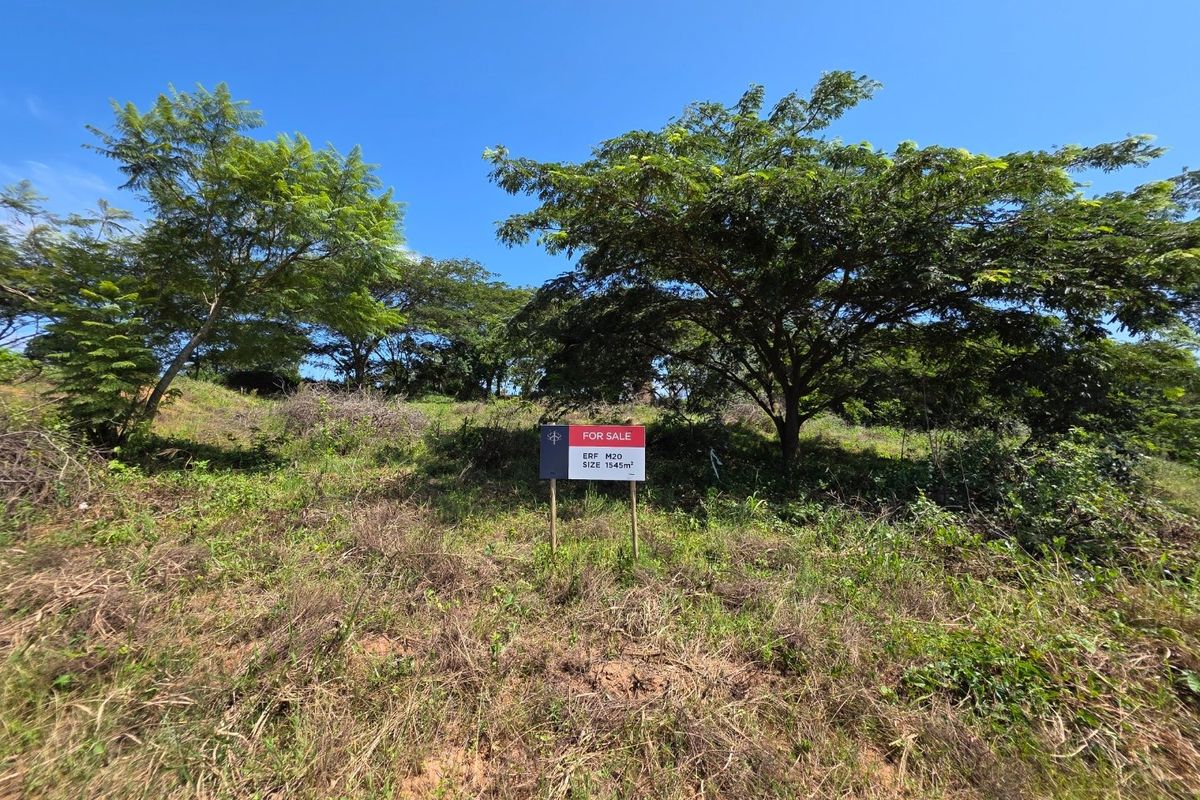 A vacant residential plot of land measuring 1545 square meters, featuring established trees and a gentle slope, ideal for future development.