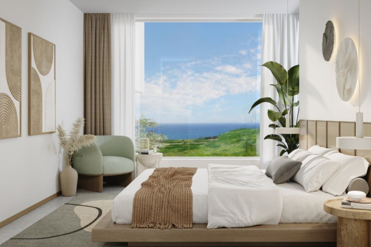 A modern, well-appointed bedroom featuring a large picture window with expansive coastal views and integrated wall lighting.
