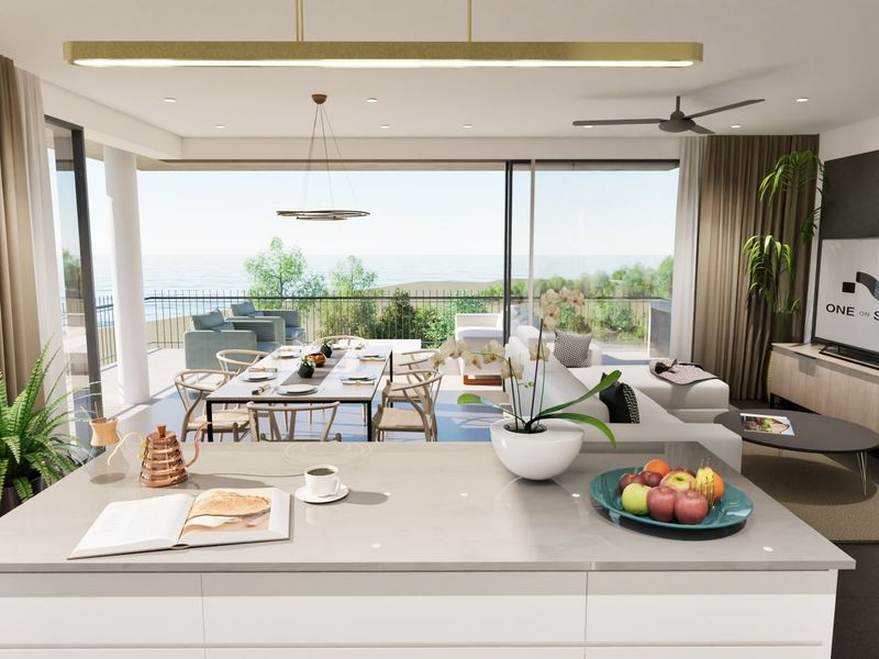 Modern open-plan living area featuring a sleek kitchen island, expansive sliding glass doors leading to a balcony, and integrated ceiling lighting.