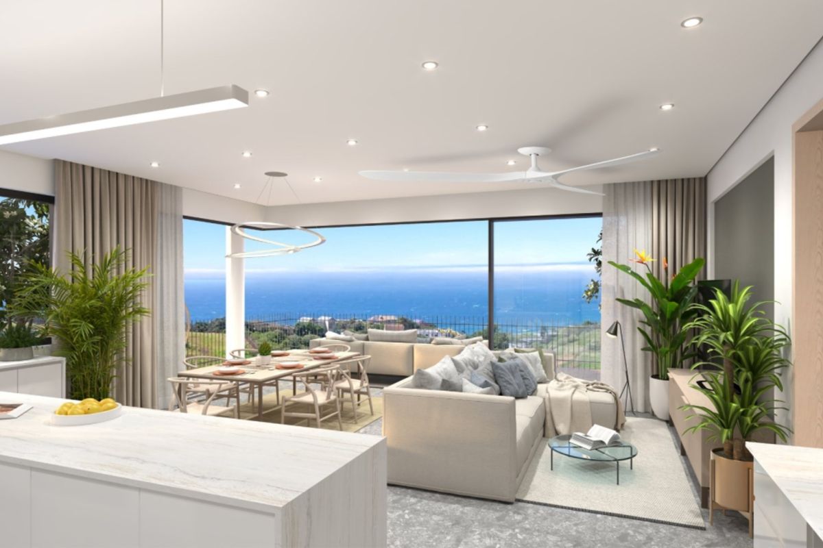 Modern open-plan living and dining area featuring a kitchen island, recessed lighting, and expansive sliding glass doors with panoramic ocean views.