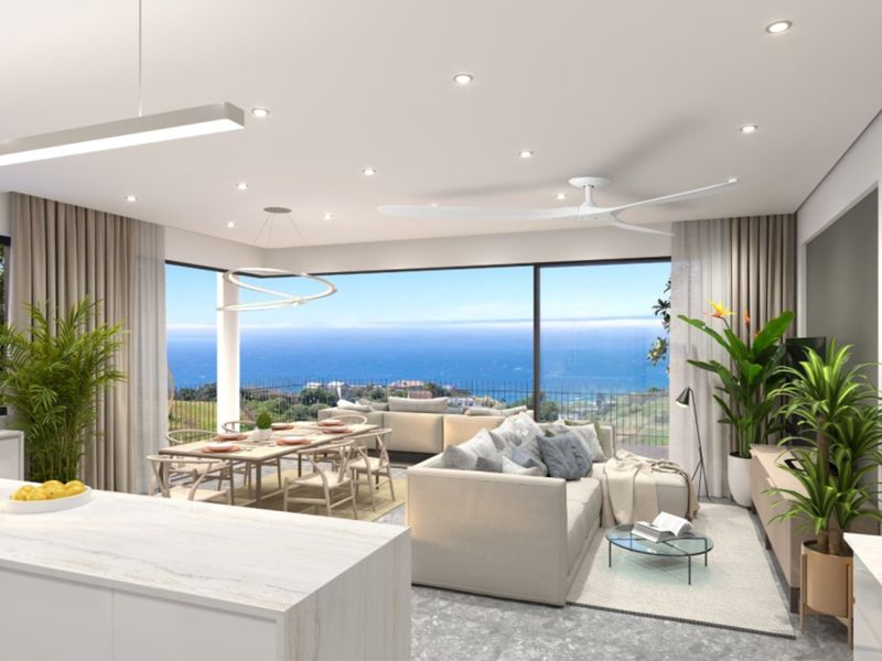 Modern open-plan living and dining area featuring a kitchen island, recessed lighting, and expansive sliding glass doors with panoramic ocean views.