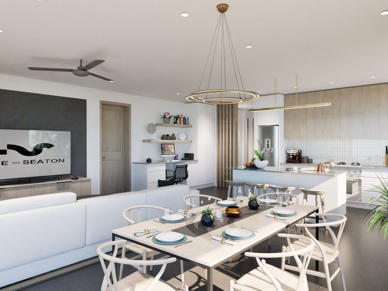 Modern open-plan living, dining, and kitchen area featuring contemporary cabinetry, a central island, built-in desk space, and high-quality finishes throughout.