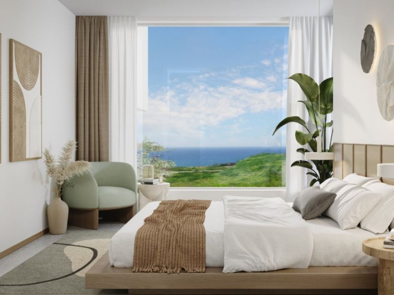 A modern, well-appointed bedroom featuring a large picture window with expansive coastal views and integrated wall lighting.