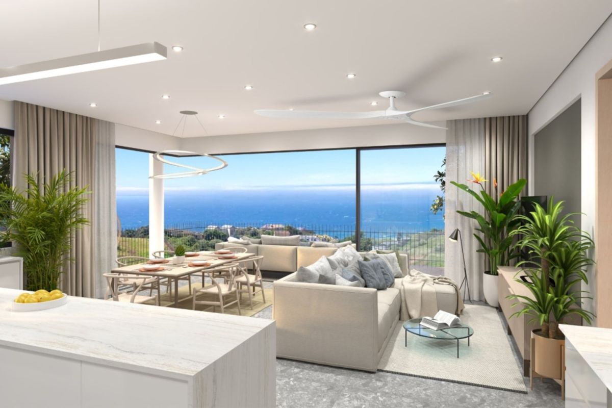 Modern open-plan living and dining area featuring a kitchen island, recessed lighting, and expansive sliding glass doors showcasing a panoramic ocean view.